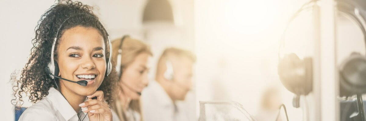 Women working as a helpdesk support, she is smiling and talking with customer