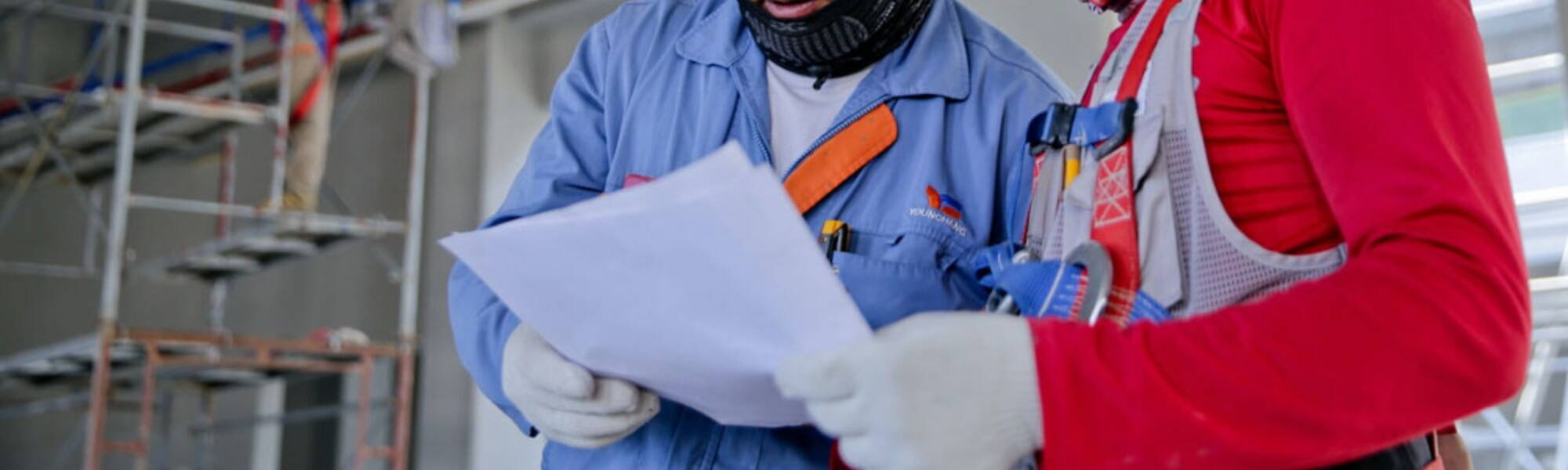 HVAC Employees in red and blu looking at paper